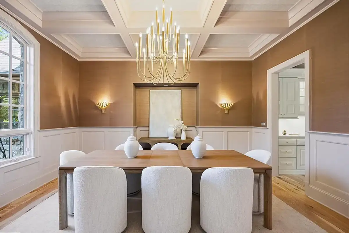 Formal dining room with chandelier and gold light fixtures, wainscoting, and cross-hatched wooden ceiling beams of 4614 36th St N