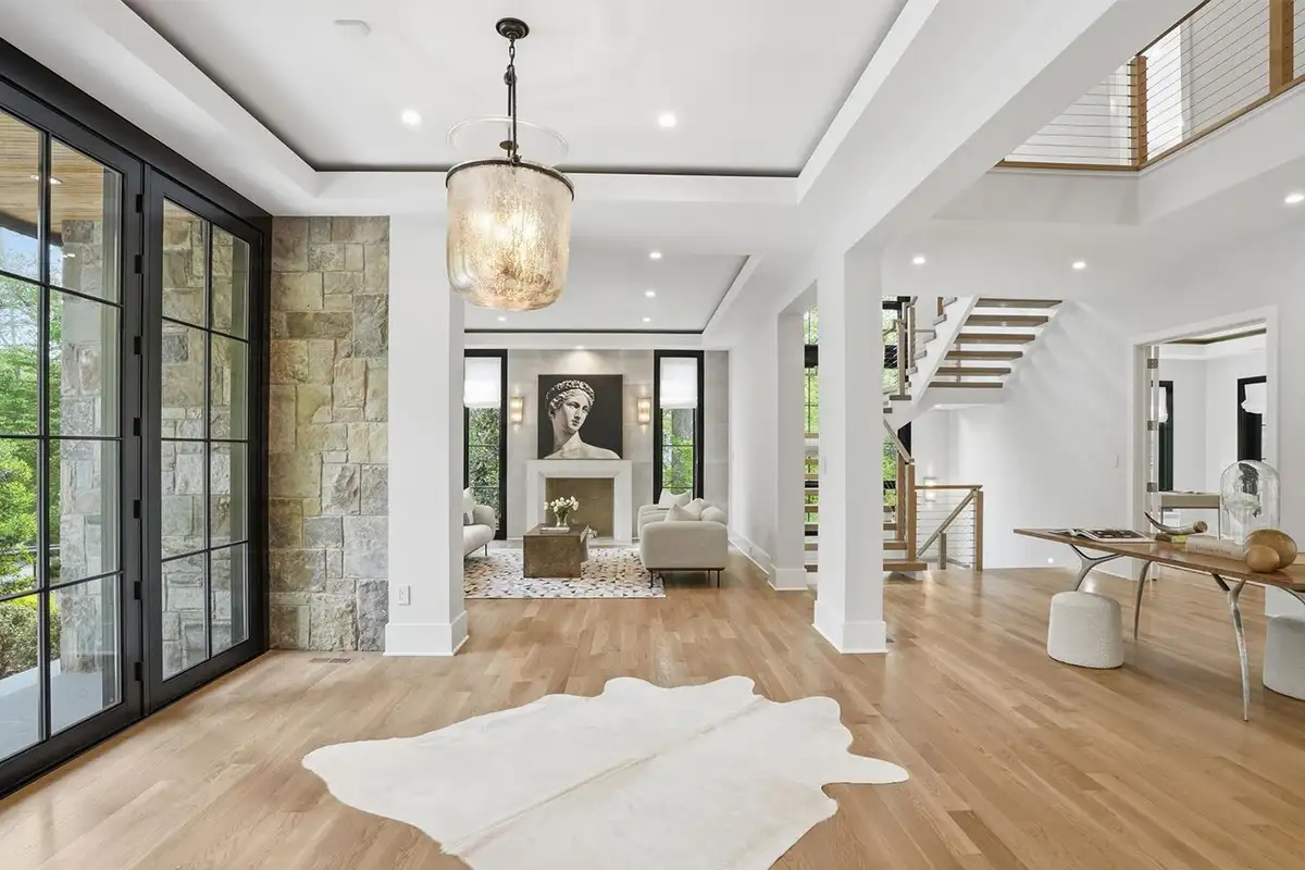 Living room and entry way with a fireplace, 20-foot ceiling, and floor to ceiling windows of 938 Saigon Rd