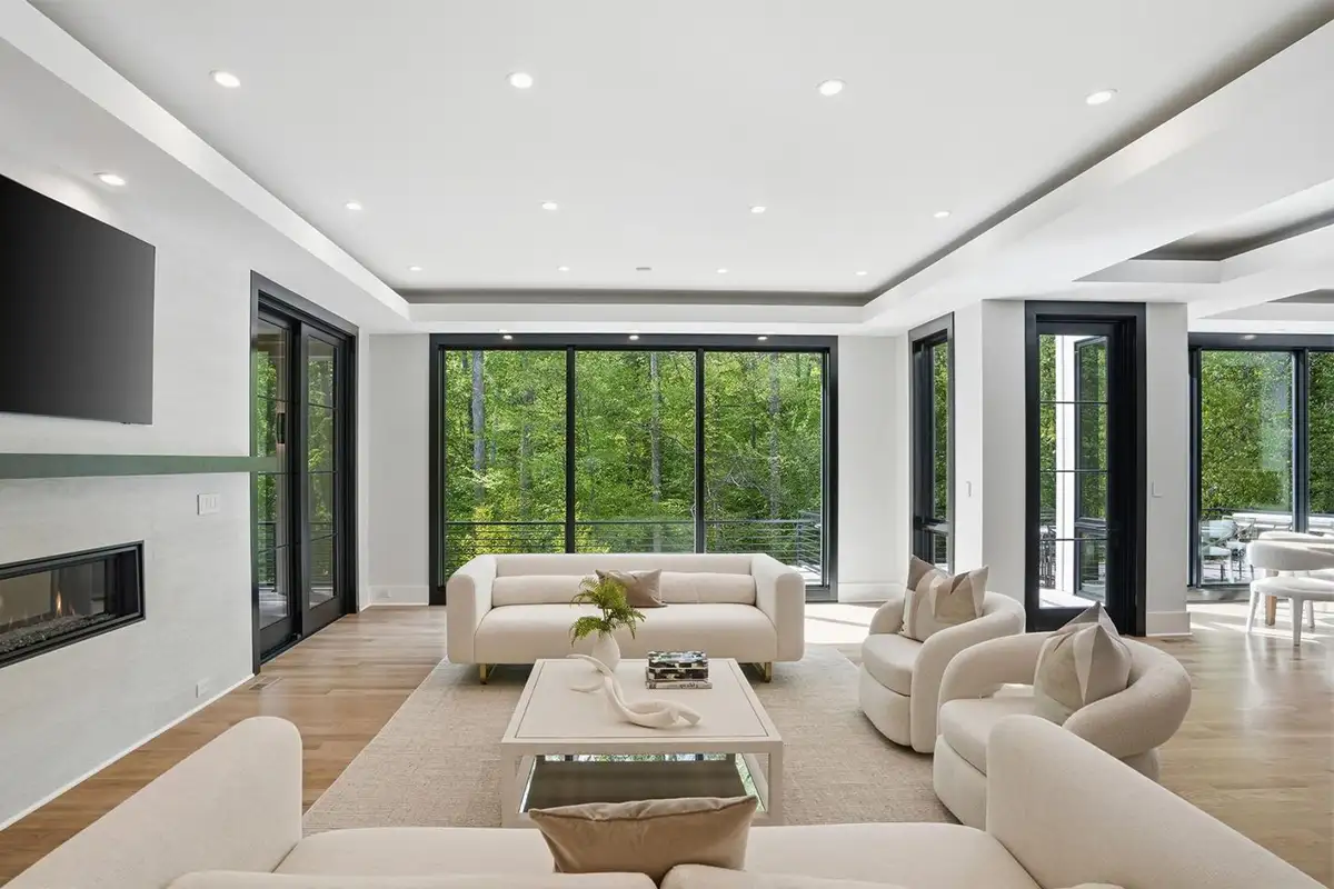 Family room with two-sided fireplace, large floor to ceiling windows, and access to screened in porch and rear terrace of 938 Saigon Rd