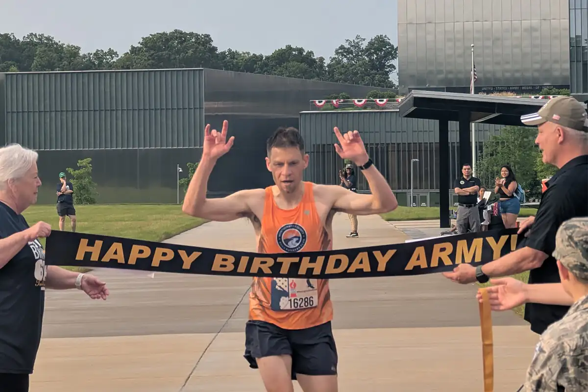 Man running through finish line at Army Birthday 6.14K
