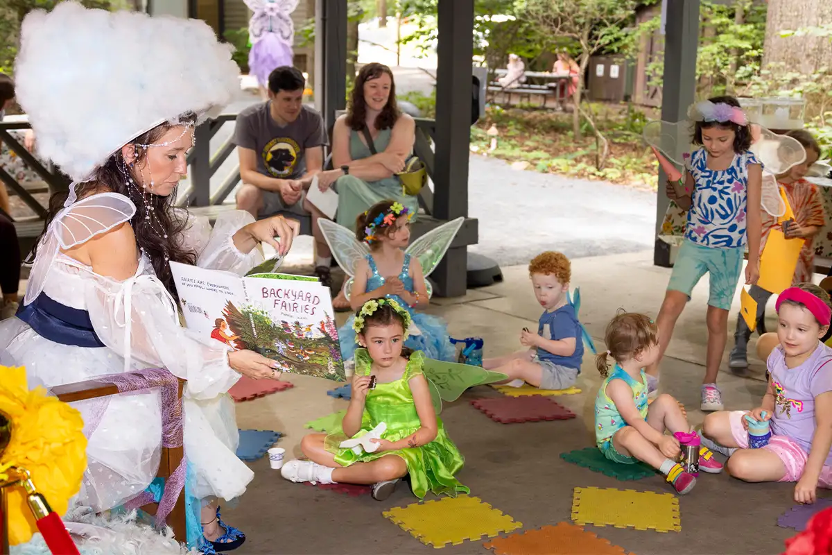 a woman in a fairy costume reads to kids dressed as fairies at the Walker Nature Center 