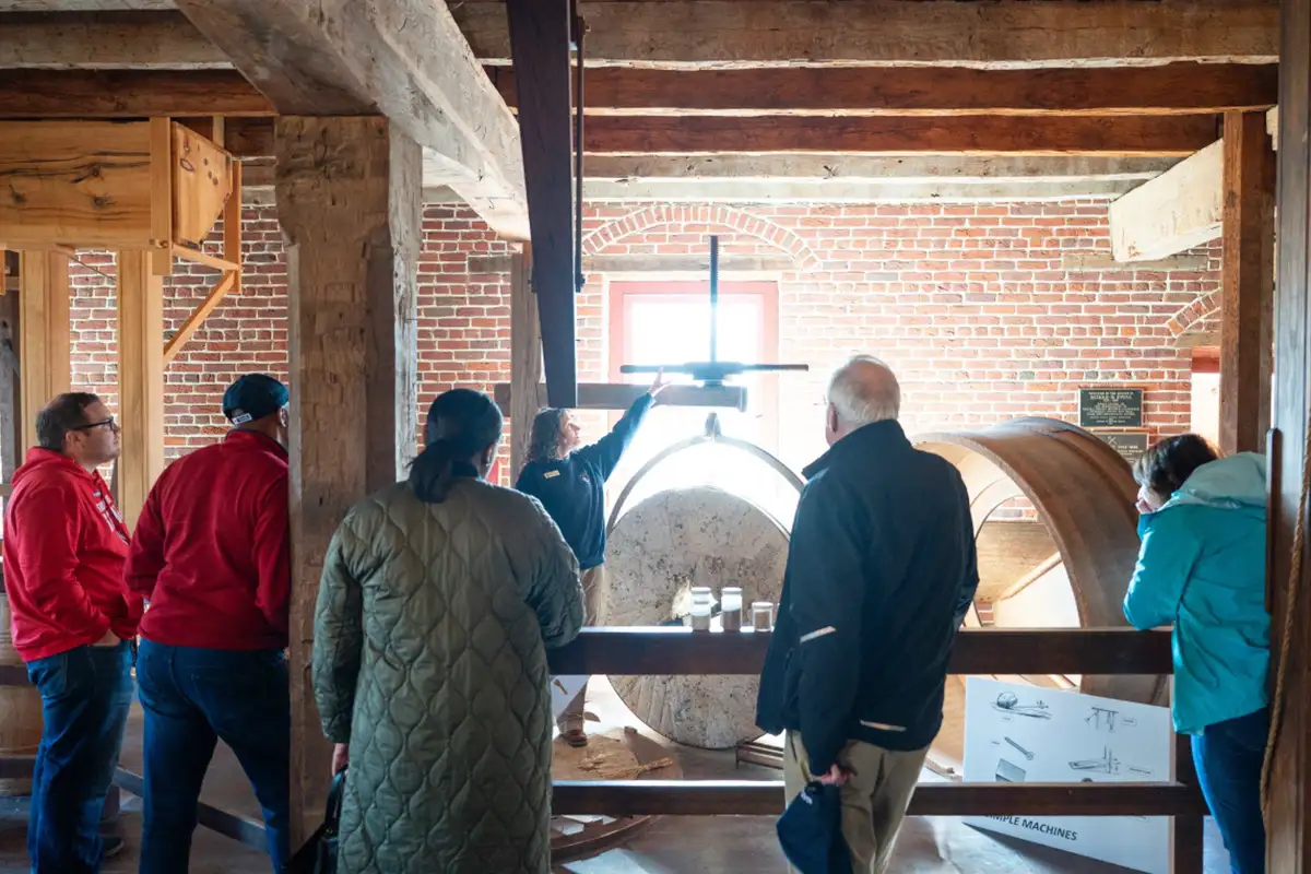 Group of people watching mill demonstration at Colvin Run Mill for Juneteenth