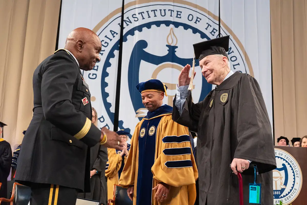 Ken Grundborg salutes as he receives his diploma