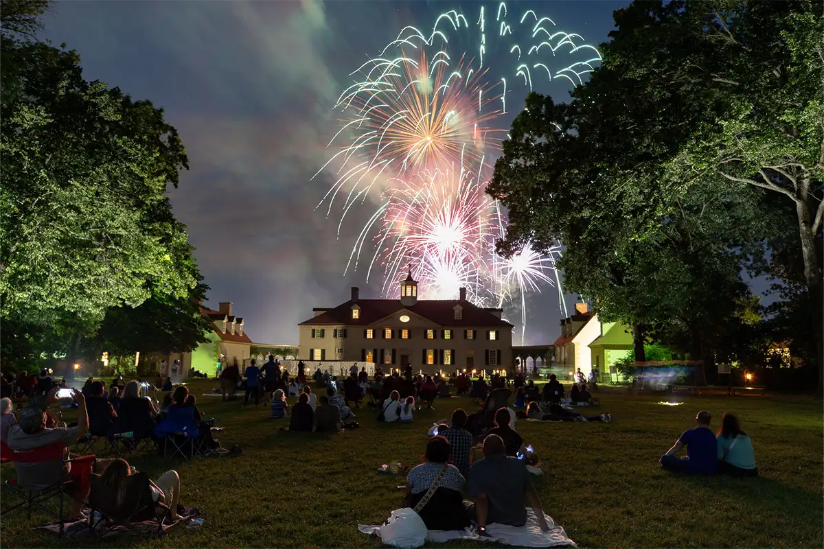 People on the lawn watching fireworks display at Mount Vernon