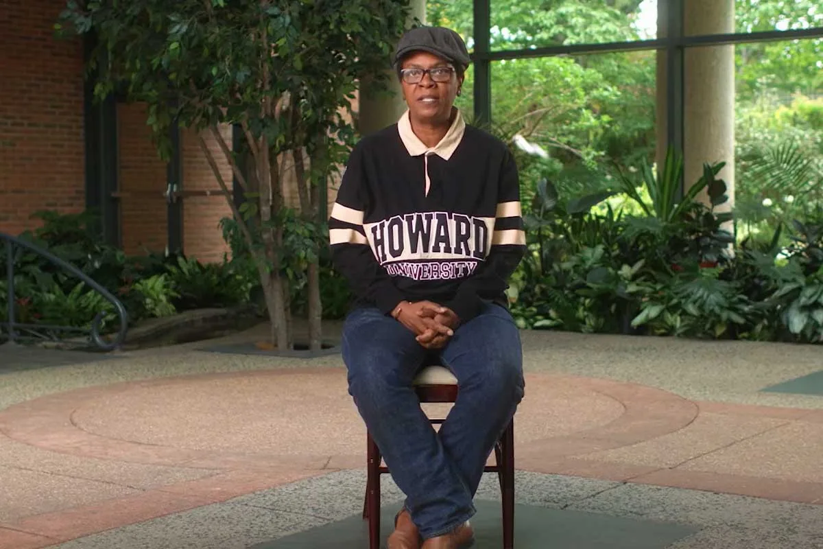 Sonja Woods sits on a chair during a documentary interview