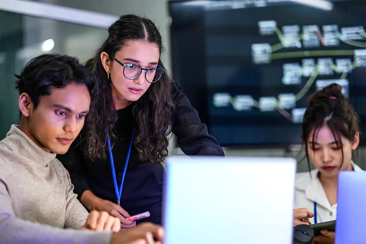 Instructor teaching student on laptop