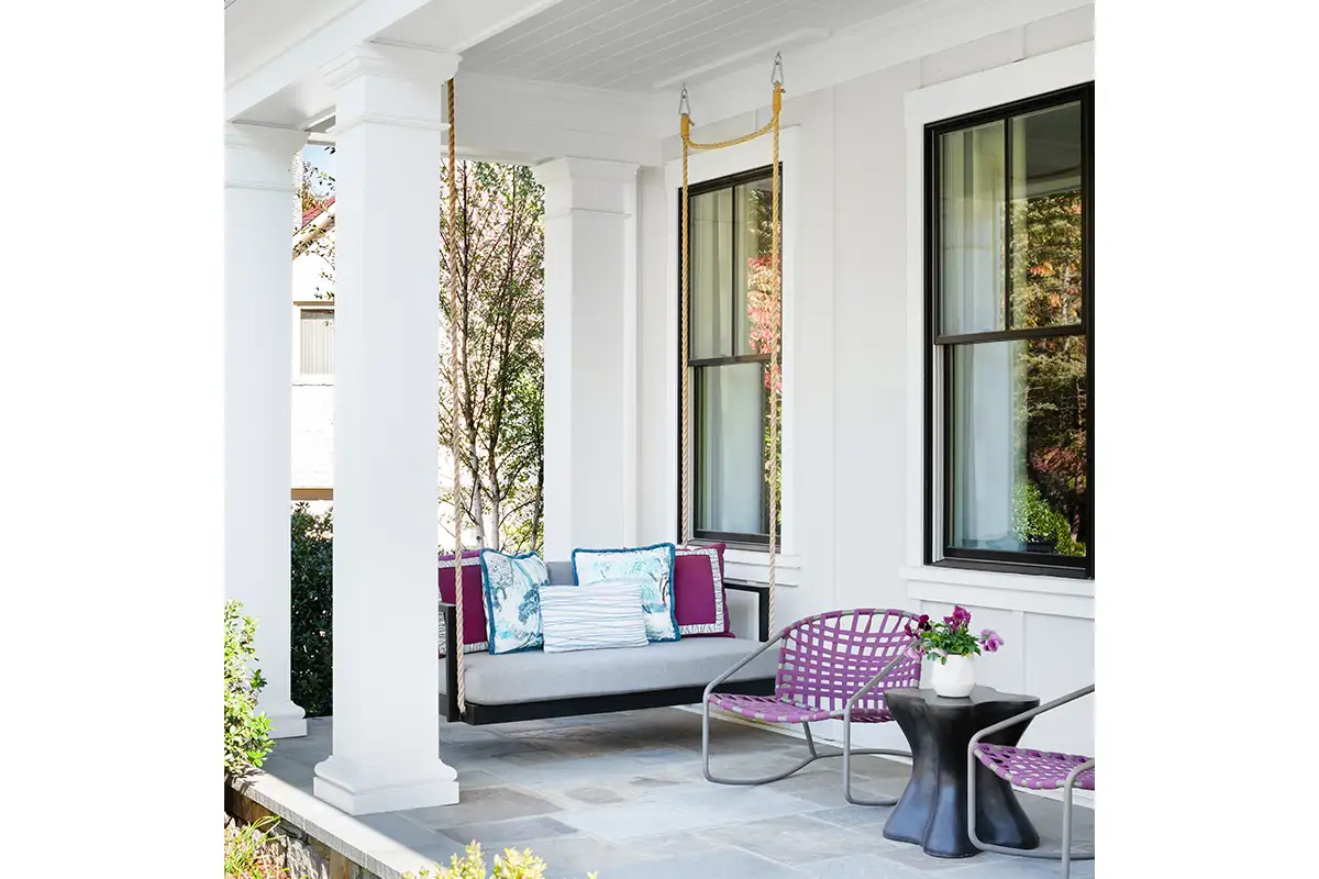 Close up of modern McLean farmhouse with blue and purple accents and porch swings