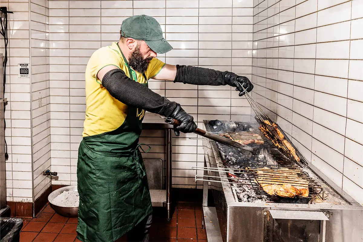 Man grilling chicken at Tio Pelé