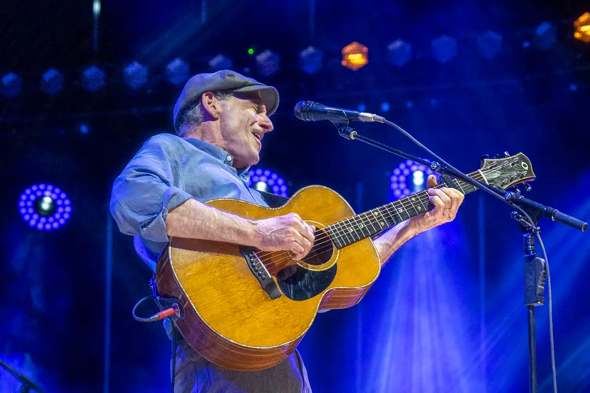 James Taylor singing and playing on stage
