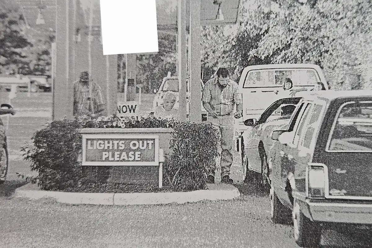 Black and white photo of cars driving into Family Drive-In Theatre