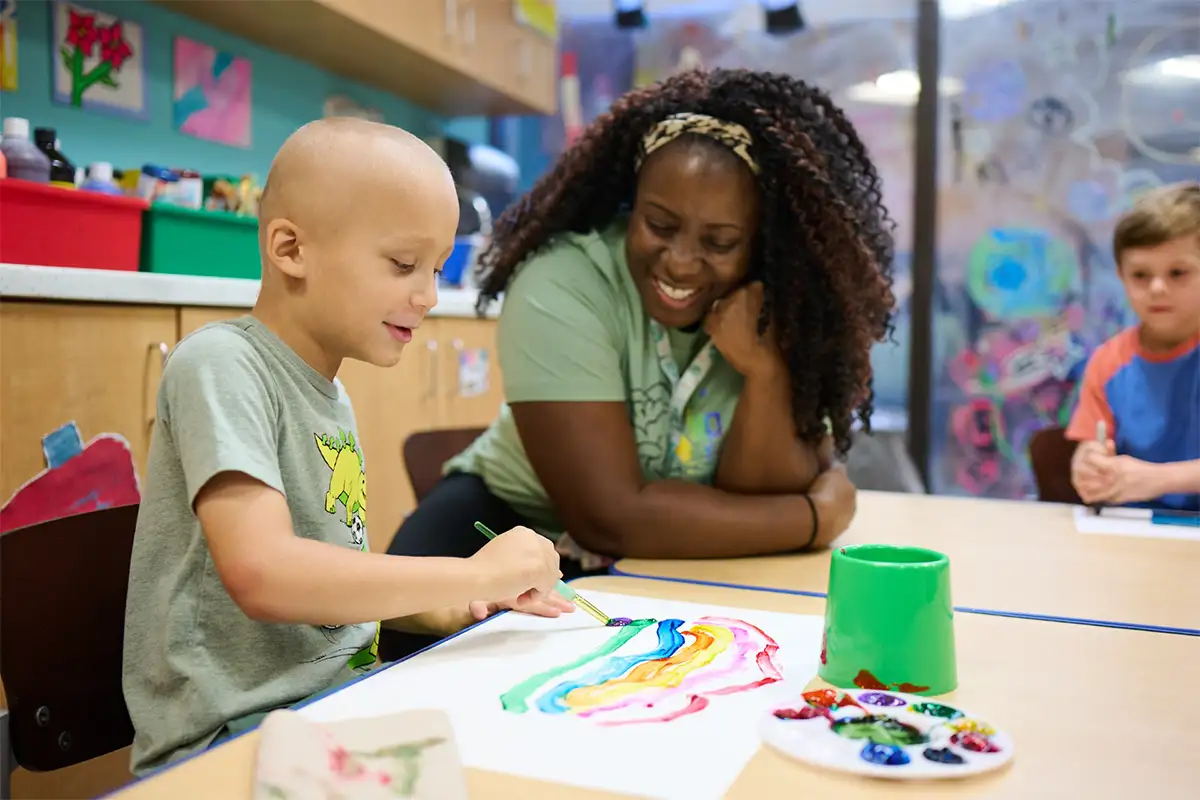 Woman watching kid paint