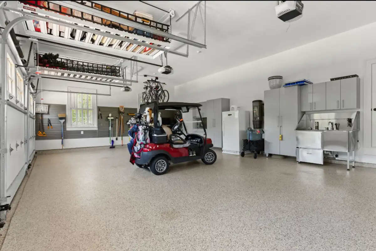 Three-car garage with custom cabinetry, storage areas, bike lifts, dog-washing station, and water-resistant flooring of 22364 Wilson Meadows Ln