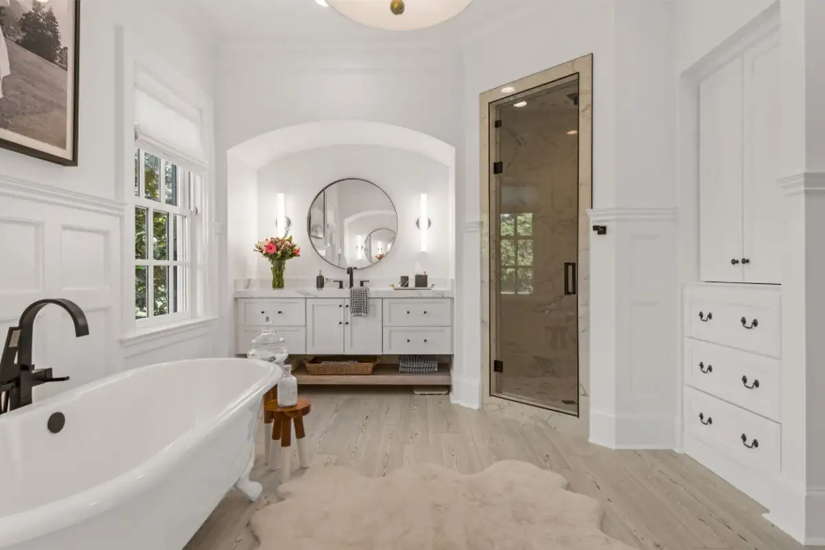 Primary bathroom with two vanities, walk in shower, footed tub, and cabinets of 22364 Wilson Meadow Ln