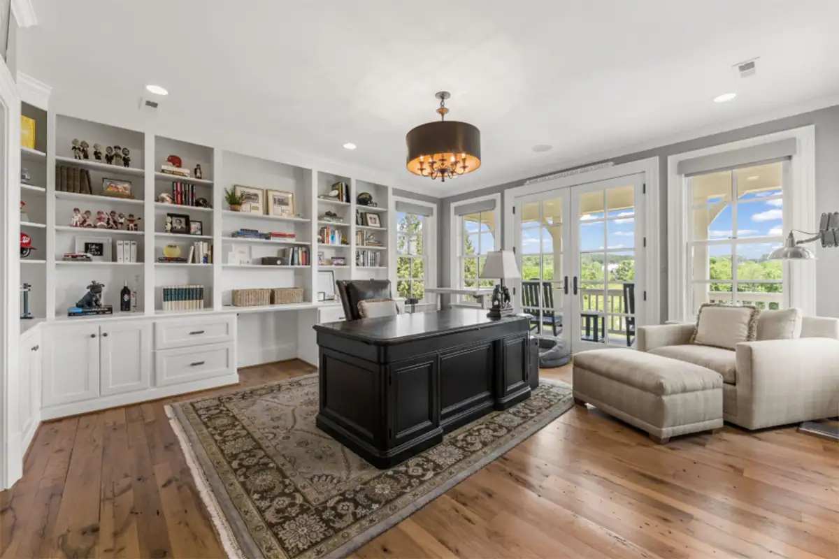 Den/home office with built-in bookshelves, seating area, and access to balcony of 22364 Wilson Meadows Ln