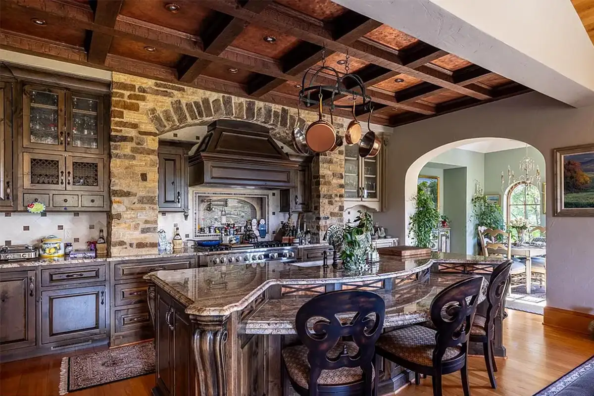 Kitchen with wood cabinetry, stone stove focal point, granite island, and breakfast nook of 2525 Gibson Ct