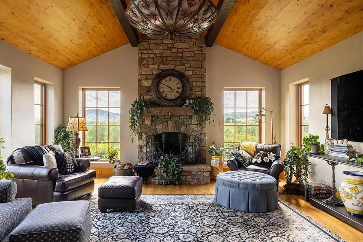 Living room with stone fireplace and large windows of 2525 Gibson Ct
