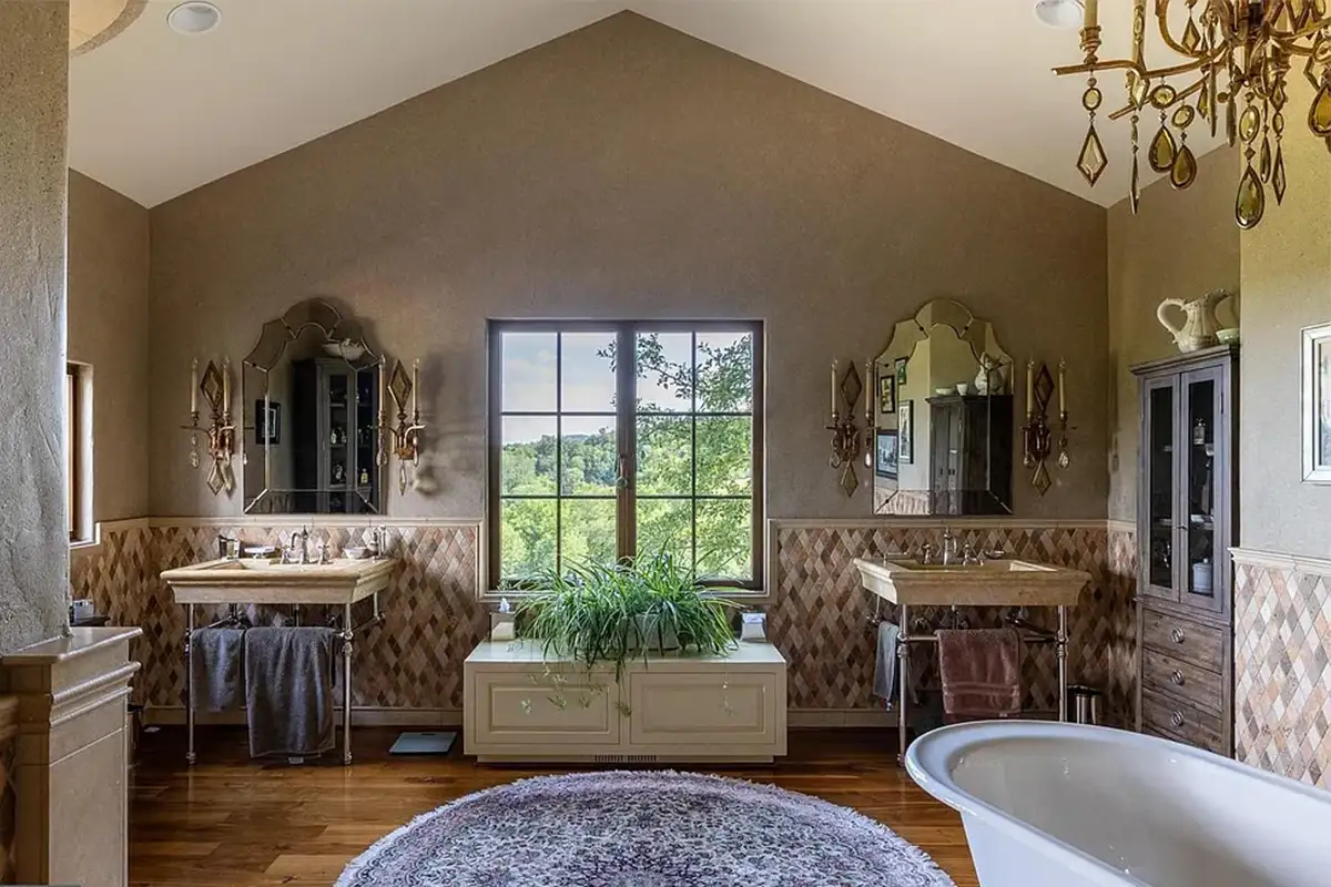 Ensuite bedroom with double vanities, terracotta tiling, and footed tub of 2525 Gibson Ct
