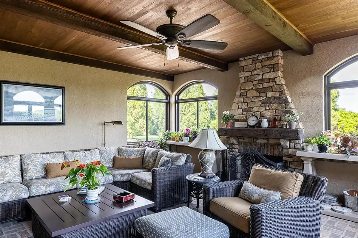 Enclosed patio with stone fireplace, arched windows, and stone flooring of 2525 Gibson Ct