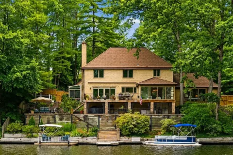 Exterior of 3431 Greentree Dr with private dock on Lake Barcroft, wrought iron balcony, and several terraces