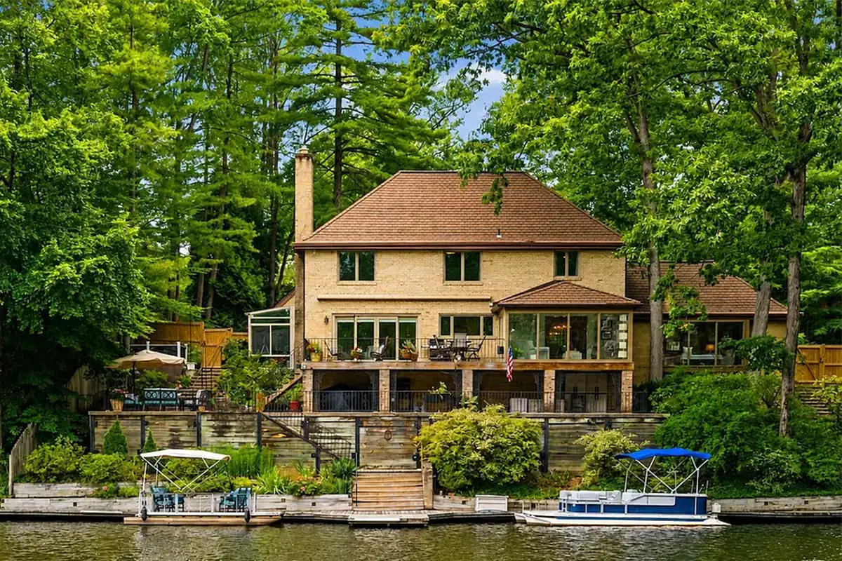 Exterior of 3431 Greentree Dr with private dock on Lake Barcroft, wrought iron balcony, and several terraces
