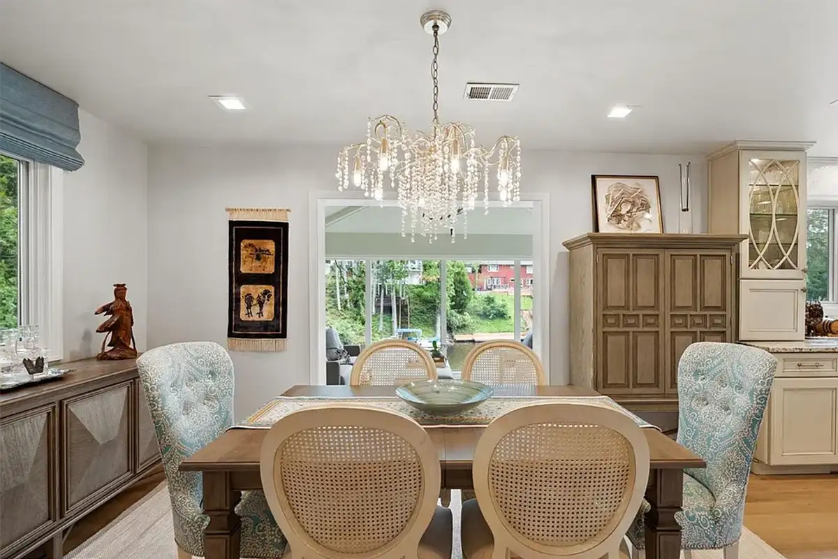 Dining area with crystal chandelier-like light fixtures, right next to kitchen
