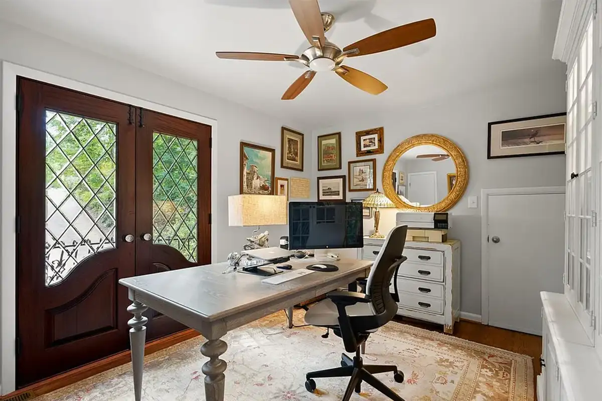 Home office with built-in cabinets and wooden double doors