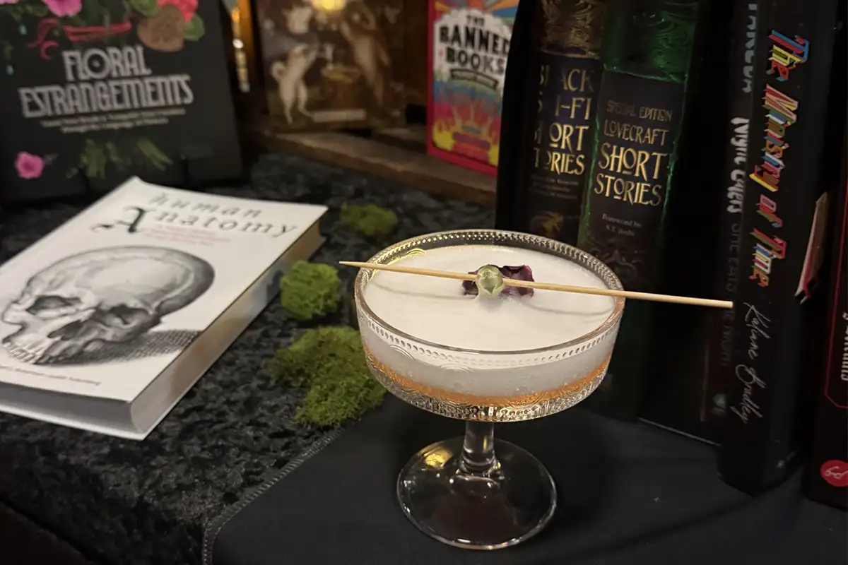 Themed drink surrounded by horror and sci-fi books at Long Dark House bookstore