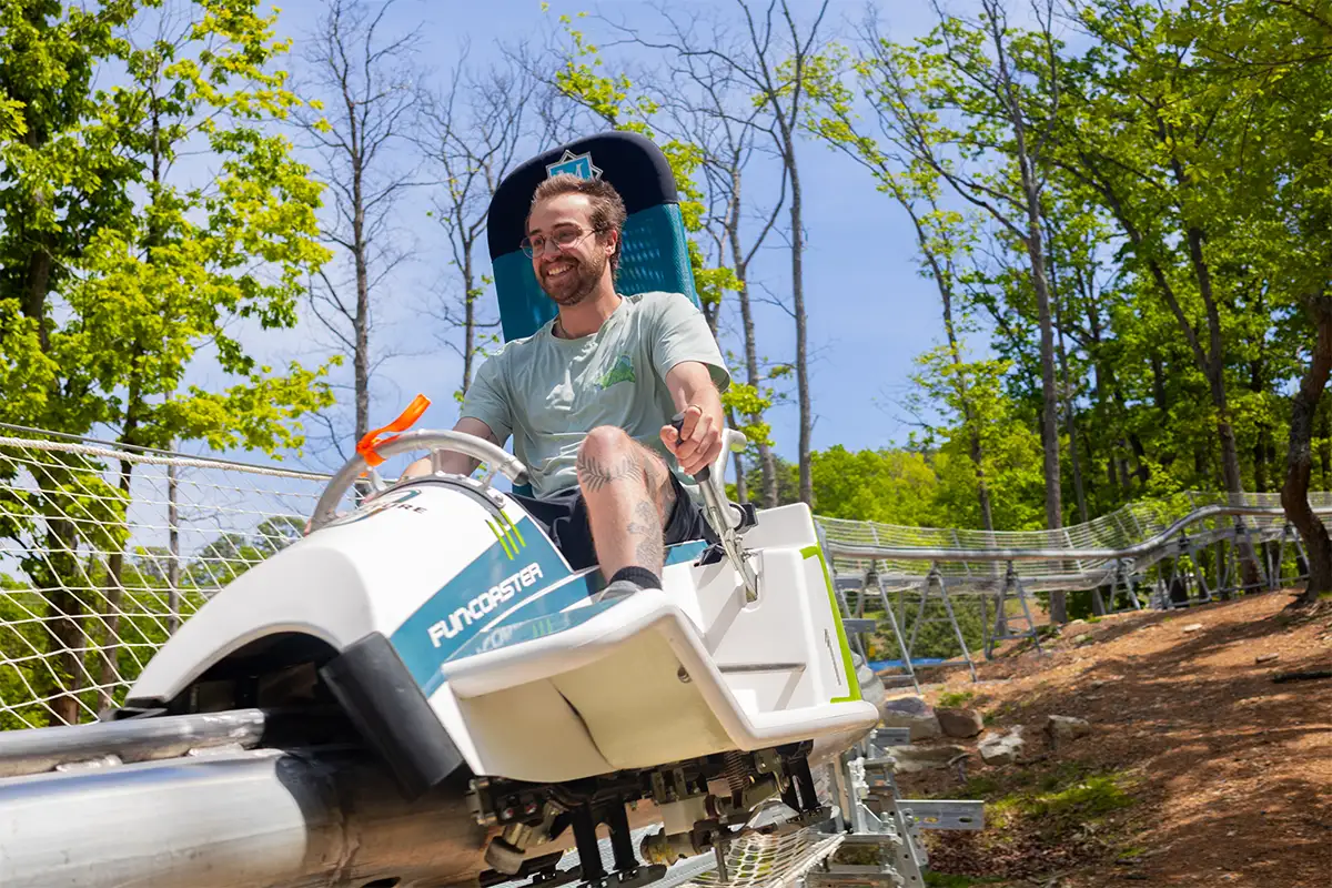 a man rides the Massanutten Mountain Mayhem alpine coaster