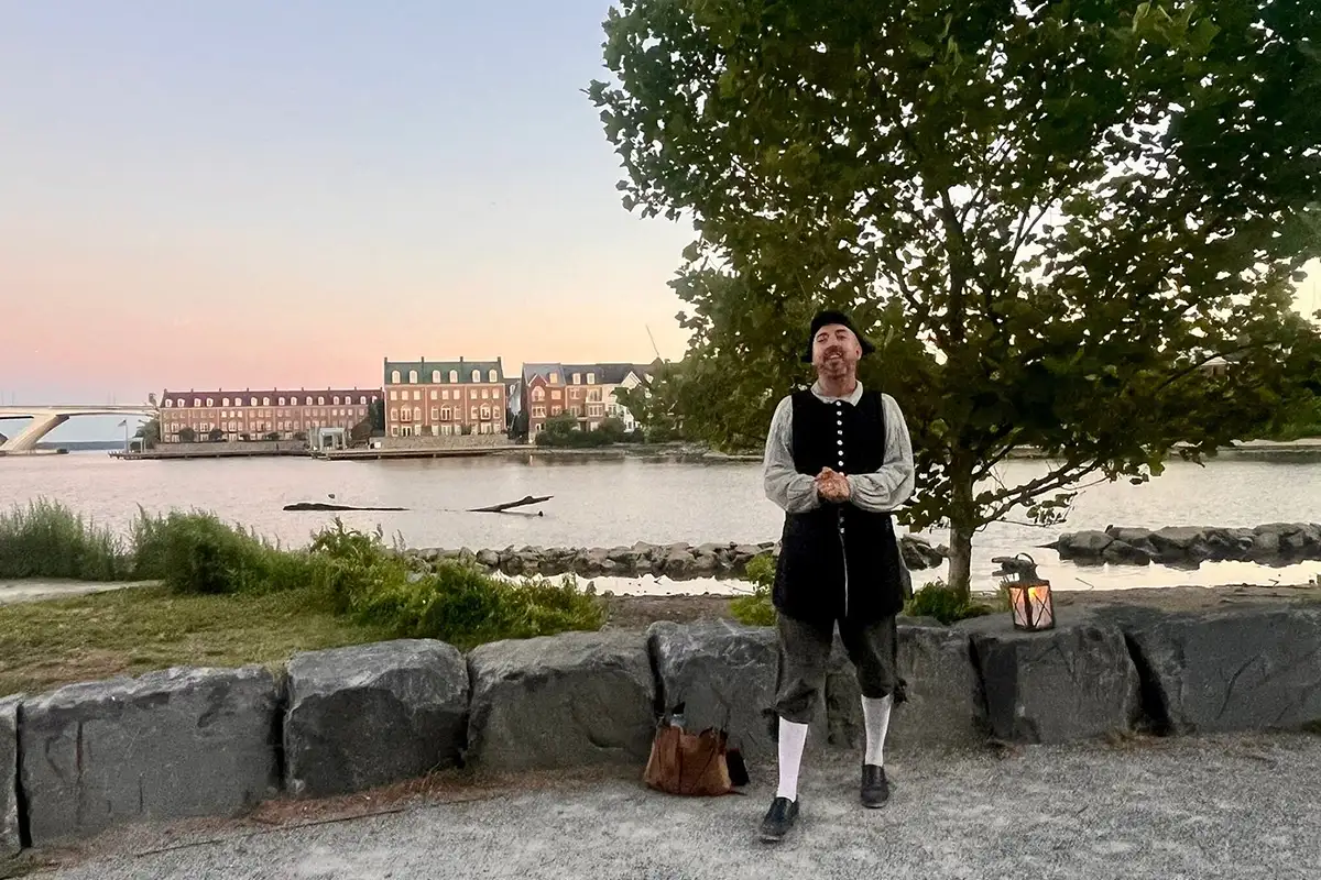 Alexandria Colonial Tours guide Jimmy Meritt standing in front of the Potomac River dressed in colonial period attire.