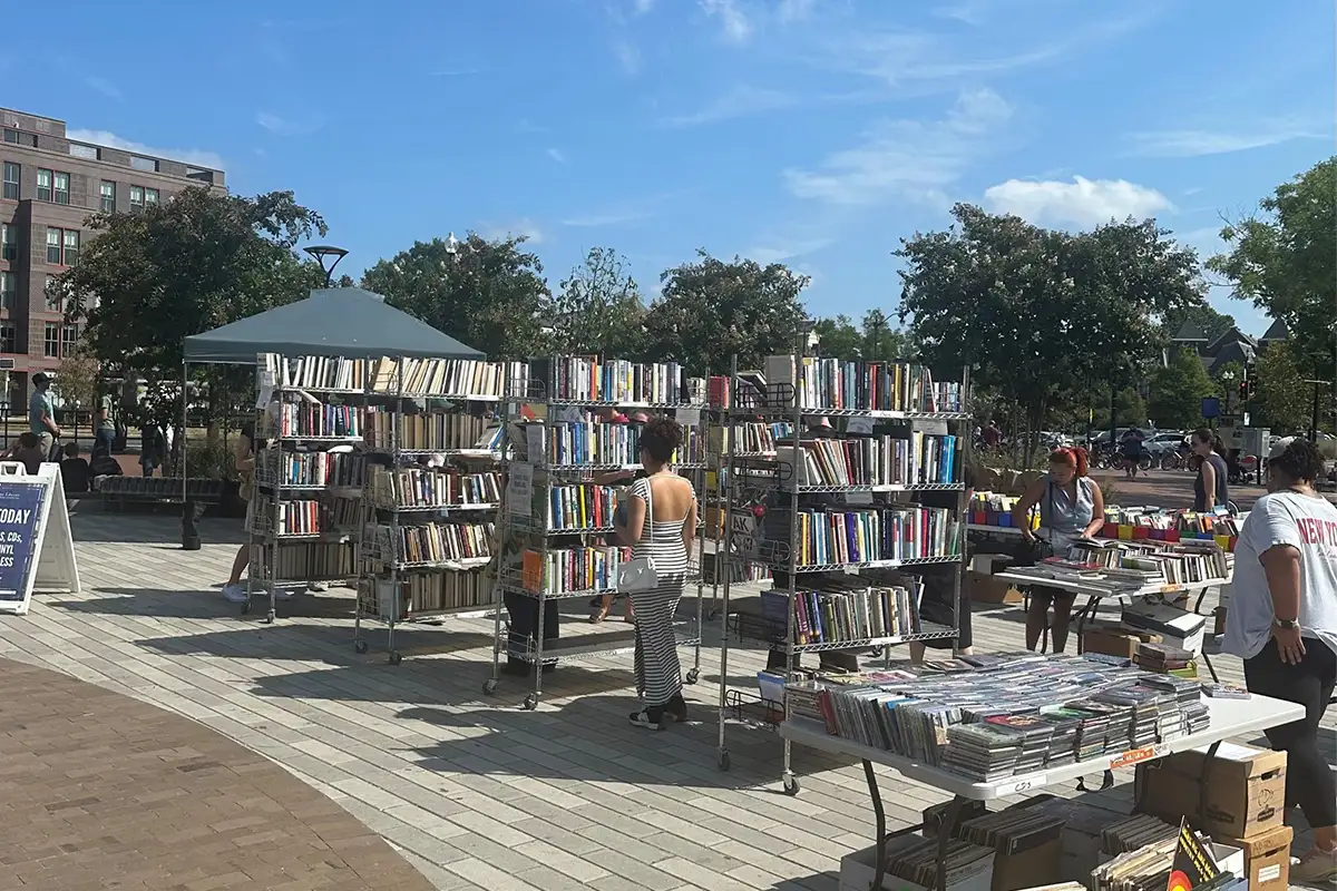 People browsing stacks of books outside