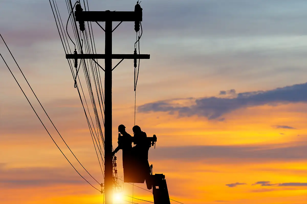 men in a bucket work on transmission power lines