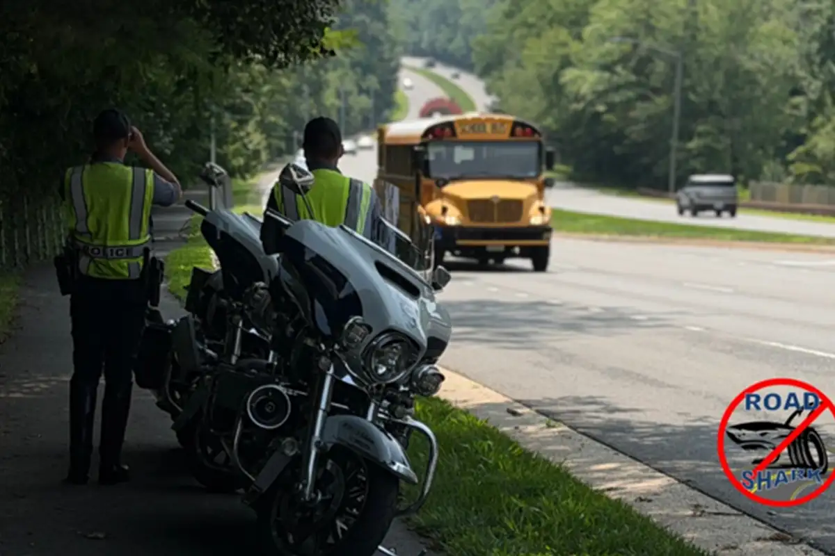 2 police officers stand beside motorcycles during road shark traffic enforcement