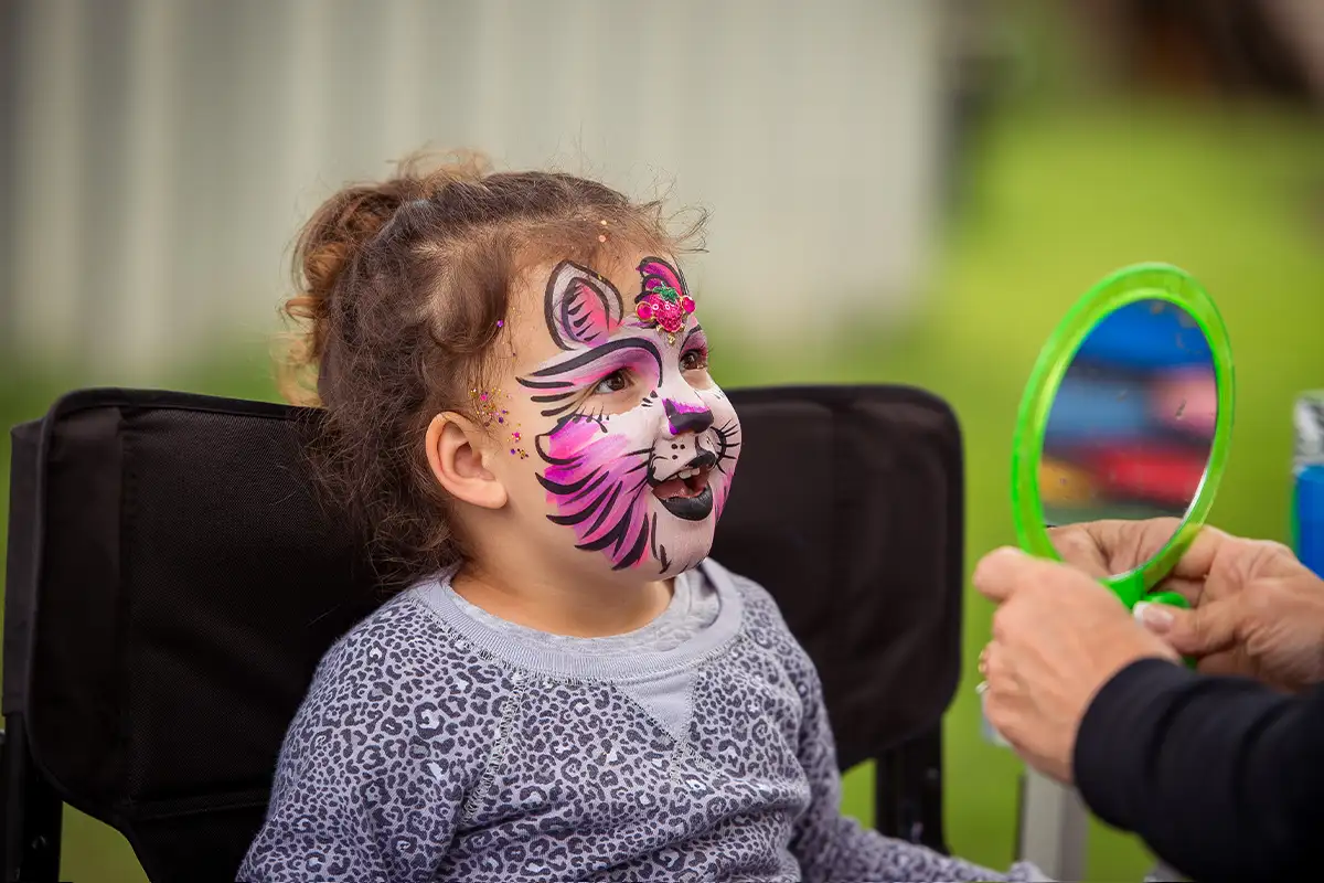 a little girl getting her face painted at the Linvilla Orchards Apple Festival
