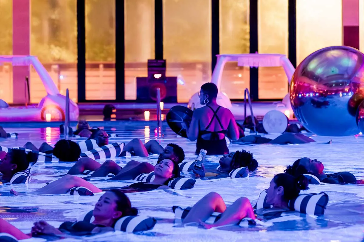 people floating in pool during sound bath