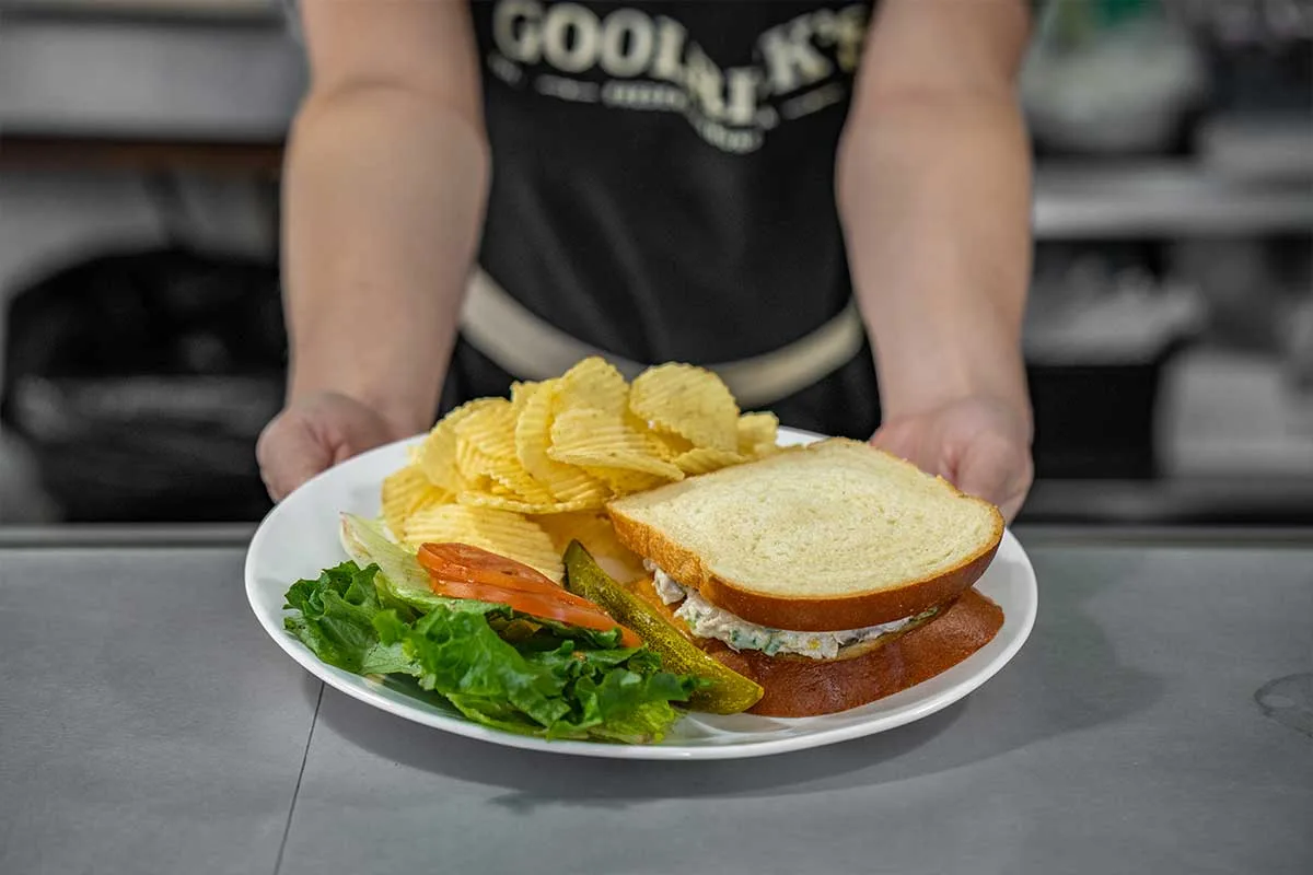 chicken salad sandwich with chips and sides