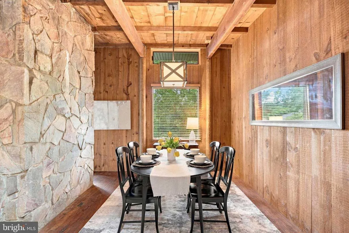 dining room with pine walls and stone wall room divider