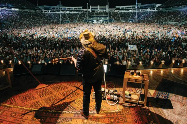 Chris Stapleton performs on stage to a full arena.