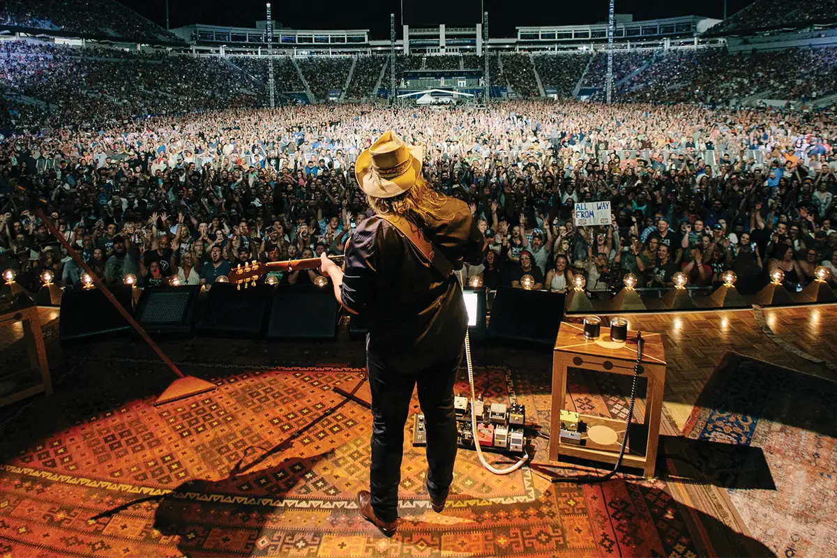 Chris Stapleton performs on stage to a full arena.