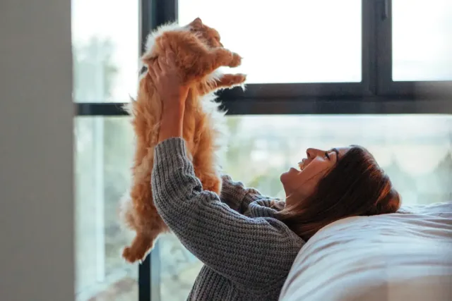 Woman holding cat in the air