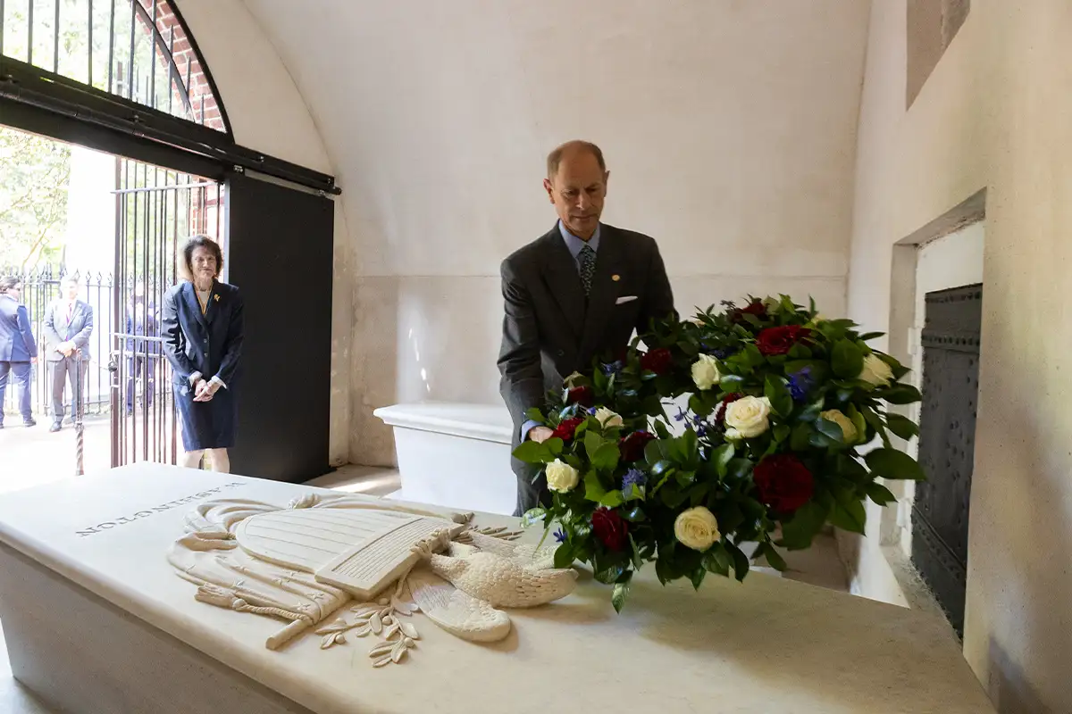 Prince Edward laying a wreath of flowers on George Washington's marble coffin at Mount Vernon