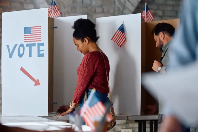 people fill out ballots at a voting site