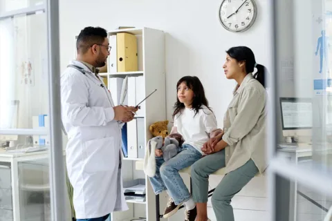 male doctor talking with mother and child