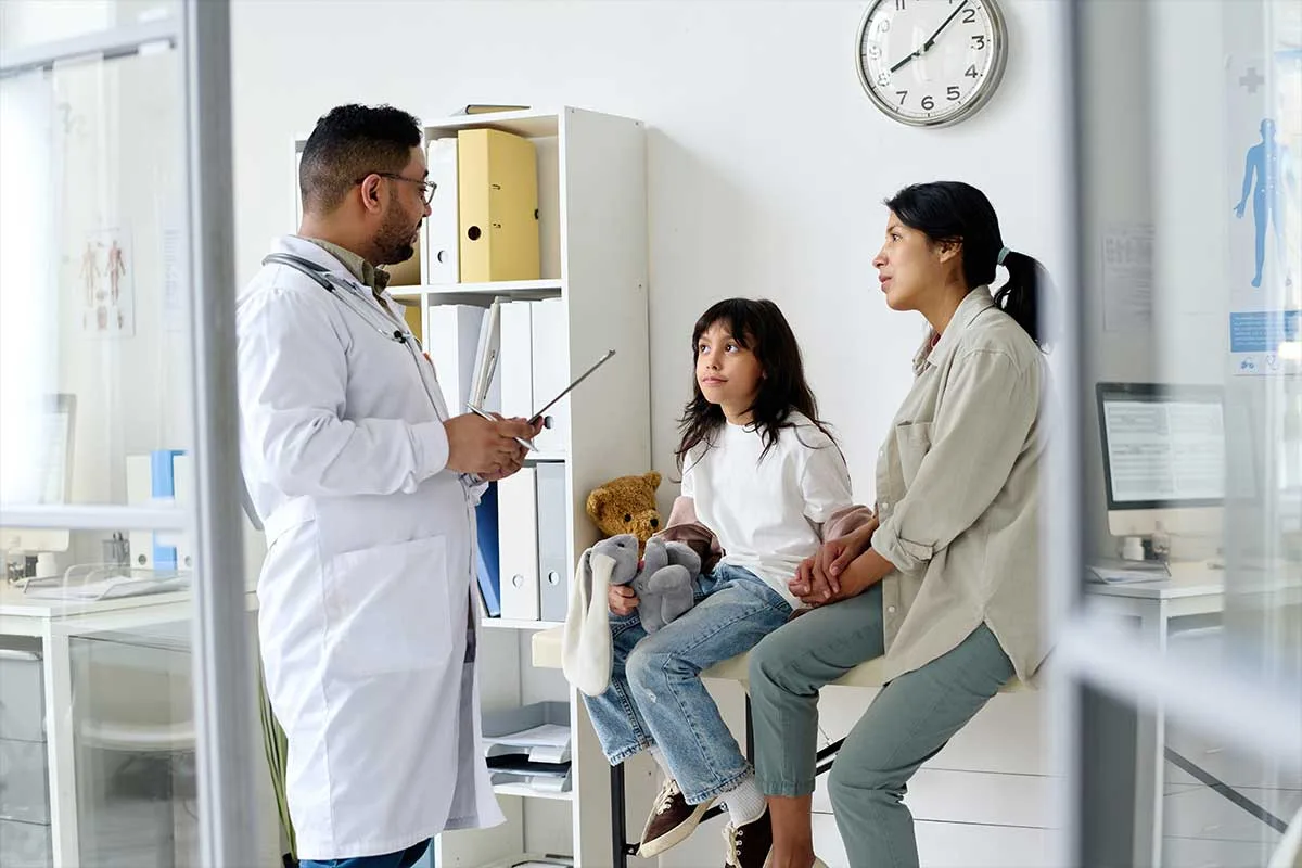 male doctor talking with mother and child