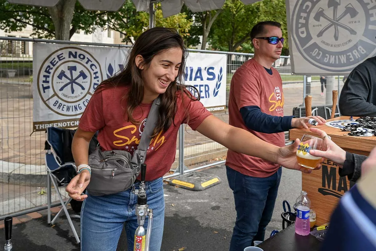 woman handing person glass of beer at snallygaster festival