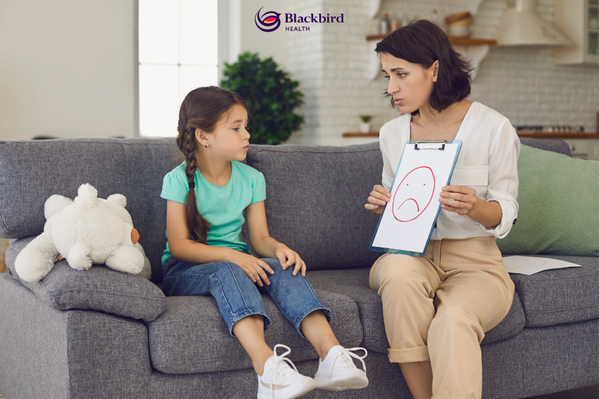 adult holding clipboard and sitting with child on couch