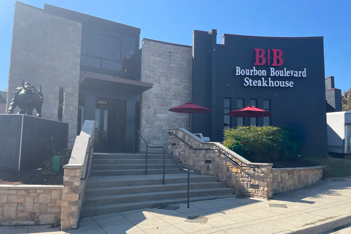 Image of steakhouse exterior at Dulles Town Center. Large angular building with steps leading up to the door and a bull statute by the door.