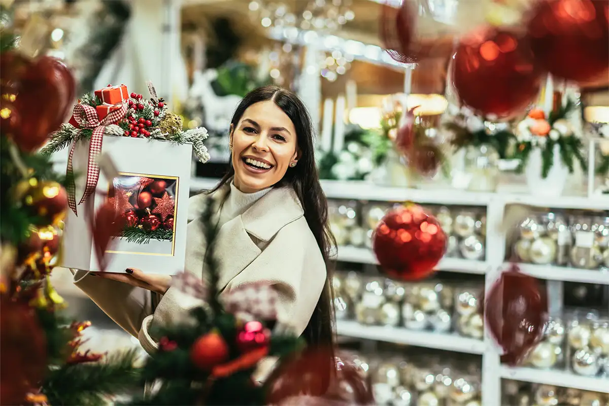 Women smiling while shopping for ornaments in a Christmas store