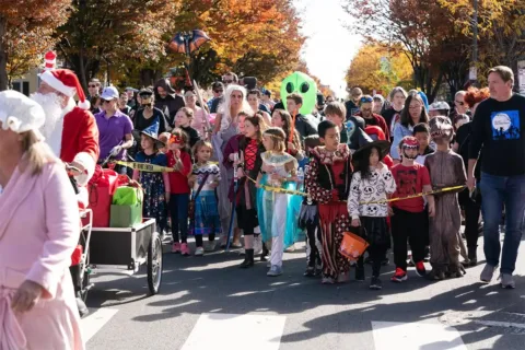 Photo of front of children's Halloween parade with kids and adults in costumes