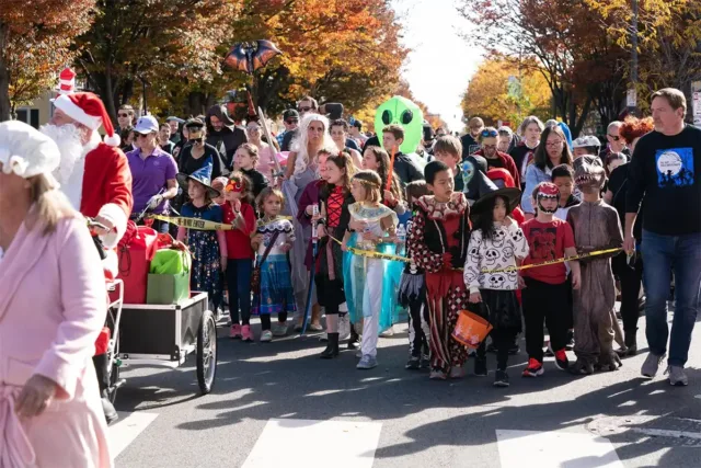 Photo of front of children's Halloween parade with kids and adults in costumes