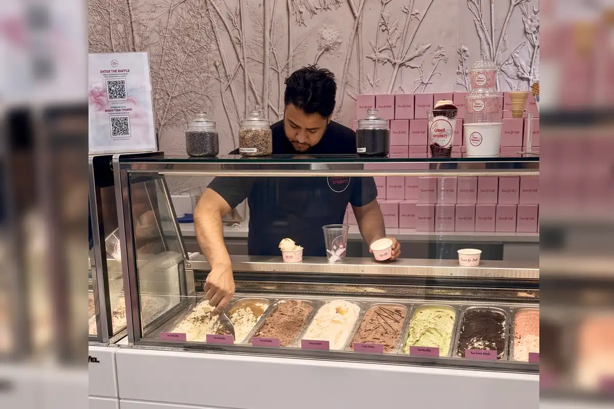 Man scooping ice cream behind the counter at Lil' Cakes creamery